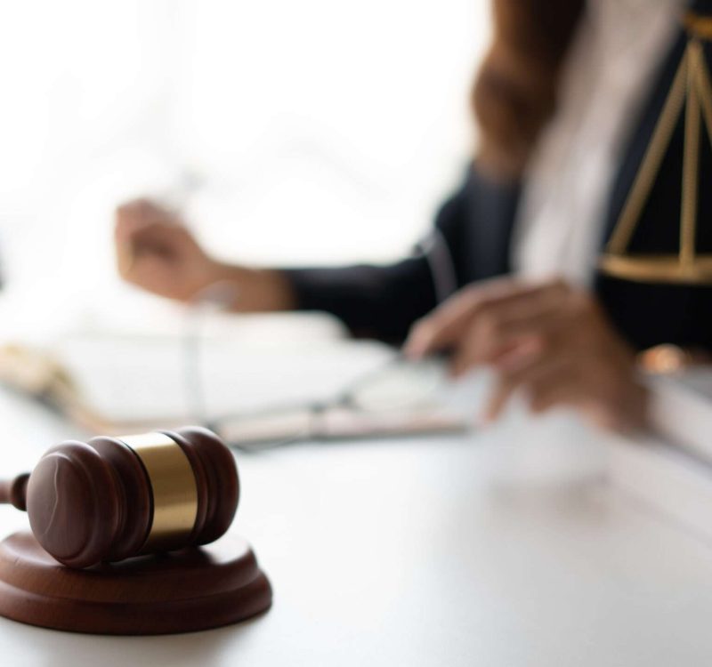 Attractive young lawyer in office Business woman and lawyers dis Attractive young lawyer in office Business woman and lawyers discussing contract papers with brass scale on wooden desk in office. Law, legal services, advice, Justice and real estate concept.