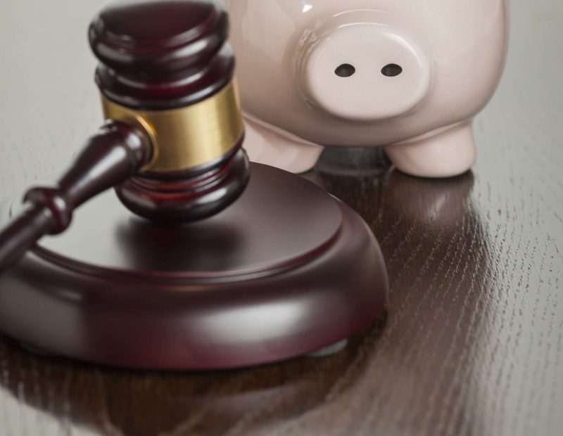 Gavel and Piggy Bank on Reflective Wooden Table. Gavel and Piggy Bank on Reflective Wooden Table.