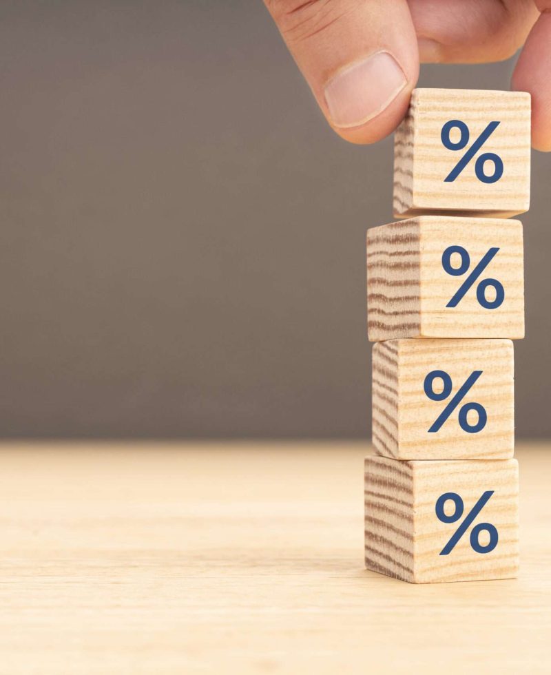 Interest rate, financial or mortgage rates concept. Hand picking a wooden block with percentage symbol icon. Copy space Interest rate, financial or mortgage rates concept. Hand picking a wooden block with percentage symbol icon. Copy space