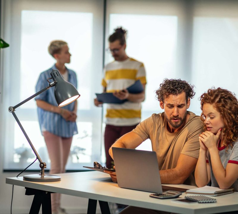 Taking on the business world with the right technology Young businesspeople working together in office and using technology